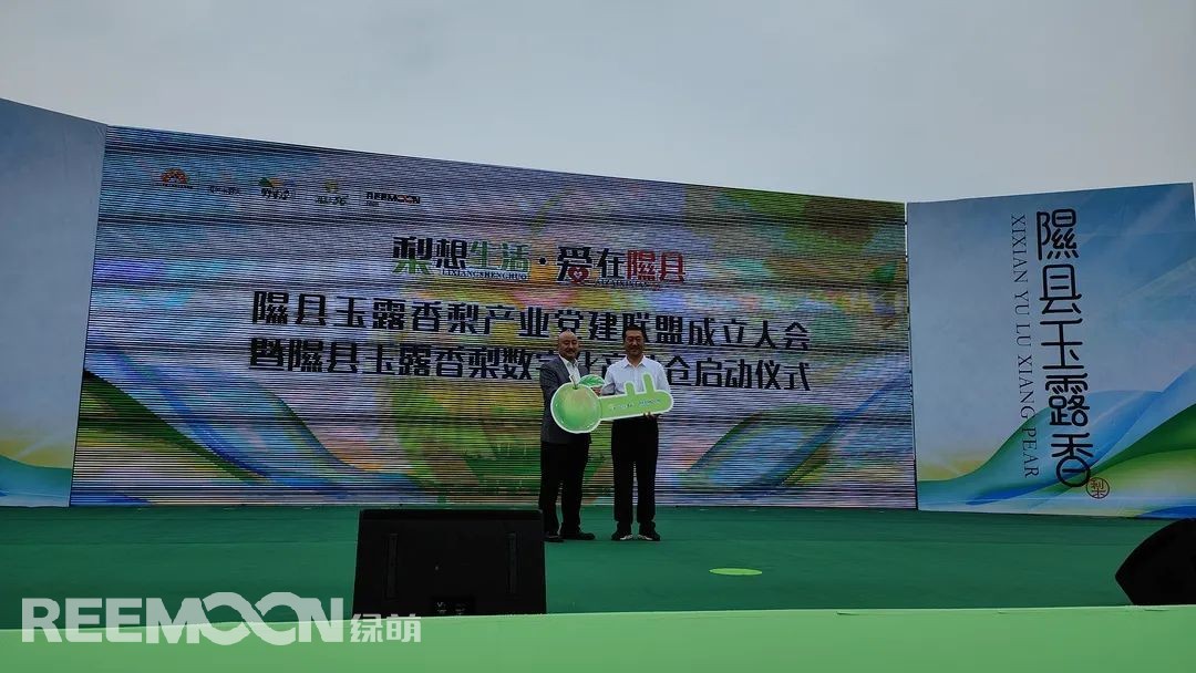 玉露香滿園，碩果迎清秋。9月3日，以“梨想生活·愛在隰縣”為主題的隰縣玉露香梨產業黨建聯盟成立大會暨隰縣玉露香梨數字化產地倉啟動儀式正式開幕。圖為：綠萌副總經理李君為玉露香梨智能分揀線授牌隰縣玉露香梨數字化產地倉啟動儀式上，江西綠萌科技控股有限公司副總經理李君為玉露香梨智能分揀線授牌，并表示將一如既往